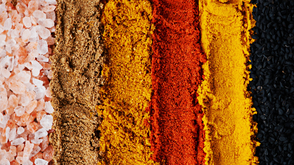 Close-up of various colored powders including pink, brown, yellow, red, and black.